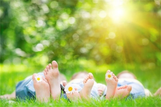 Kids laying in the grass barefoot 