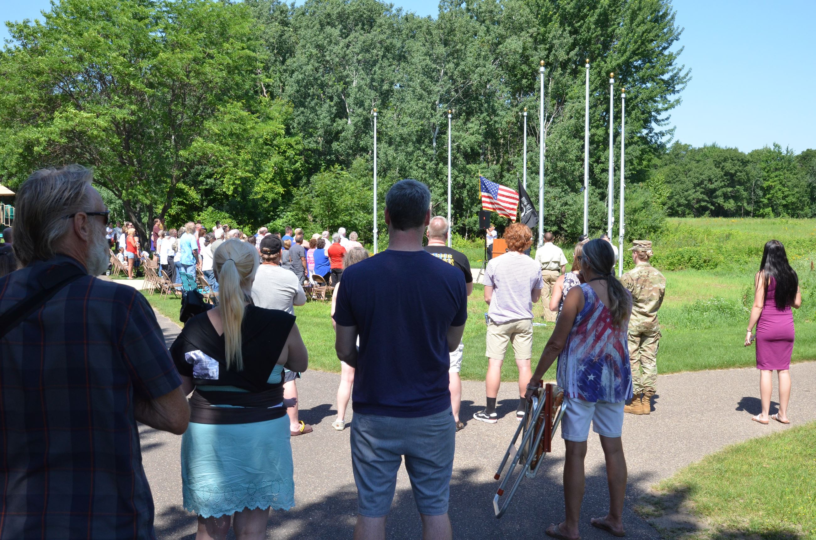 Attendees of the service stand for the flag raising