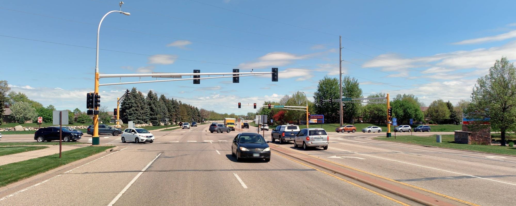 Image of 109th Avenue at Radisson Road and Tournament Players Parkway. Stoplights and cars in traffic lanes.